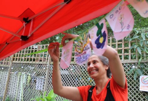 Photo of Arts Practitioner Maryam, putting up artwork.