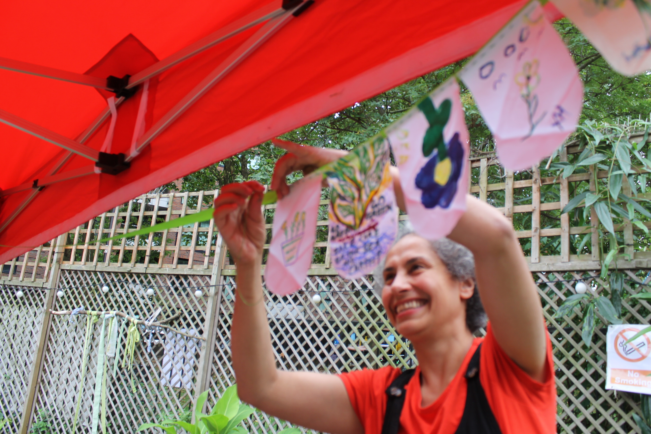 Photo of Arts Practitioner Maryam, putting up artwork.